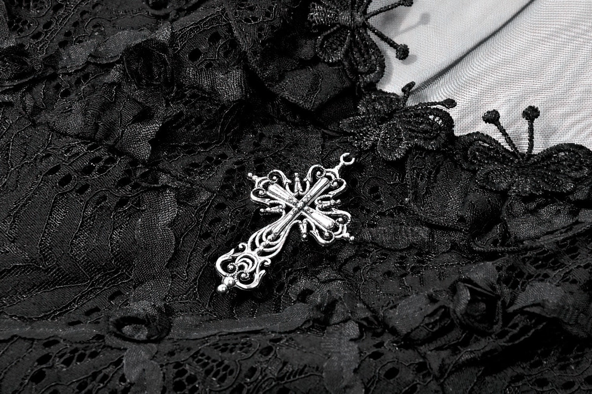 Close-up of decorative silver cross on Dark Romantic Lace Mini Dress with Corset Waist and Cross, showcasing delicate lace detail.