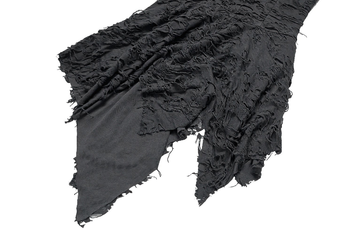 Close-up of the shredded black fabric texture.