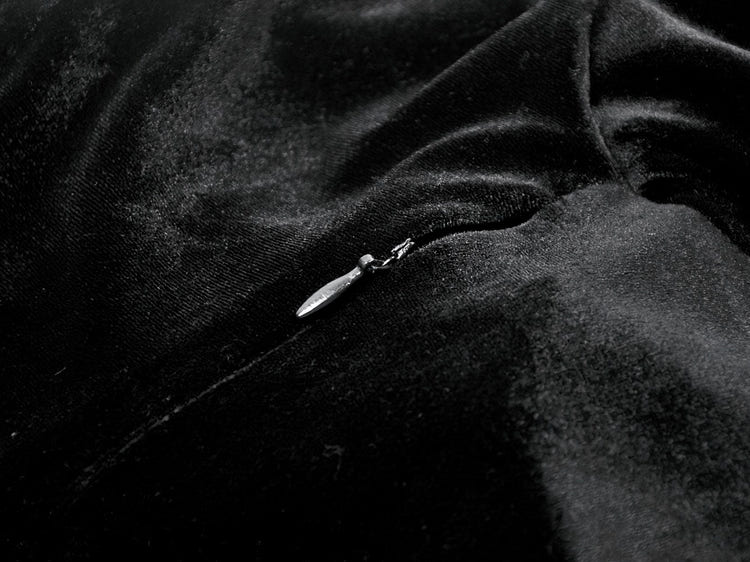 Close-up of the zipper on a Women's Gothic Velvet Maxi Dress with Lace Bell Sleeves against a black velvet fabric.