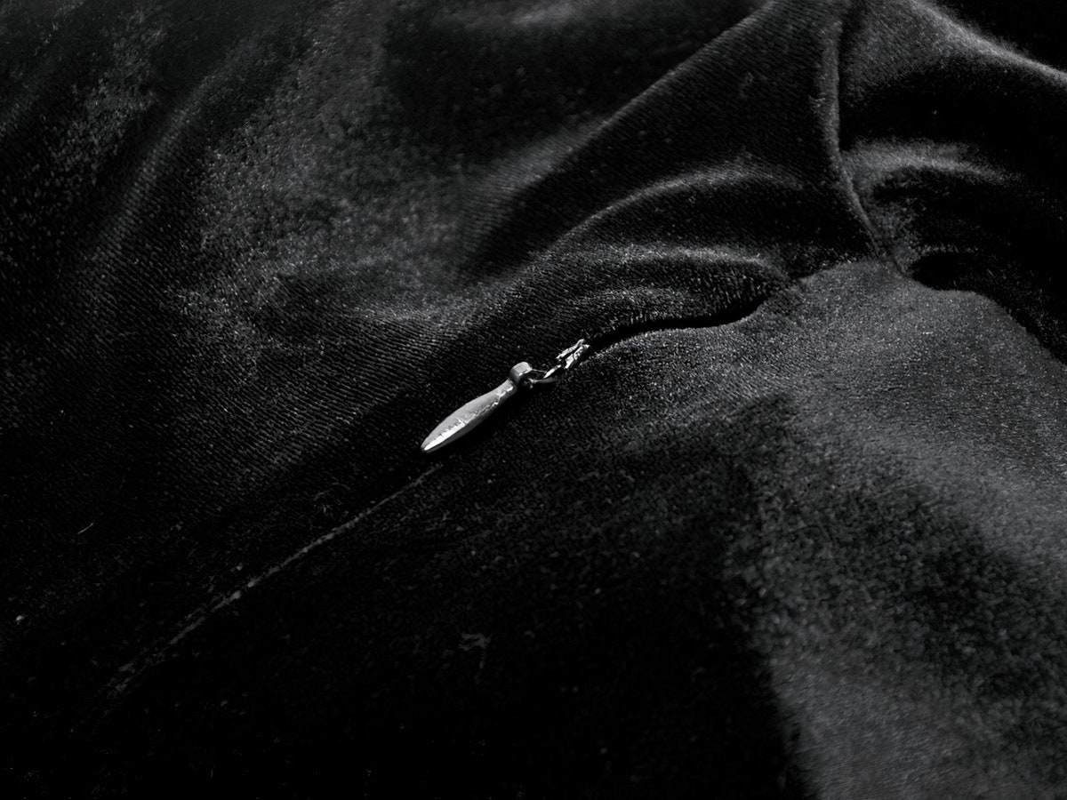 Close-up of the zipper on a Women's Gothic Velvet Maxi Dress with Lace Bell Sleeves against a black velvet fabric.